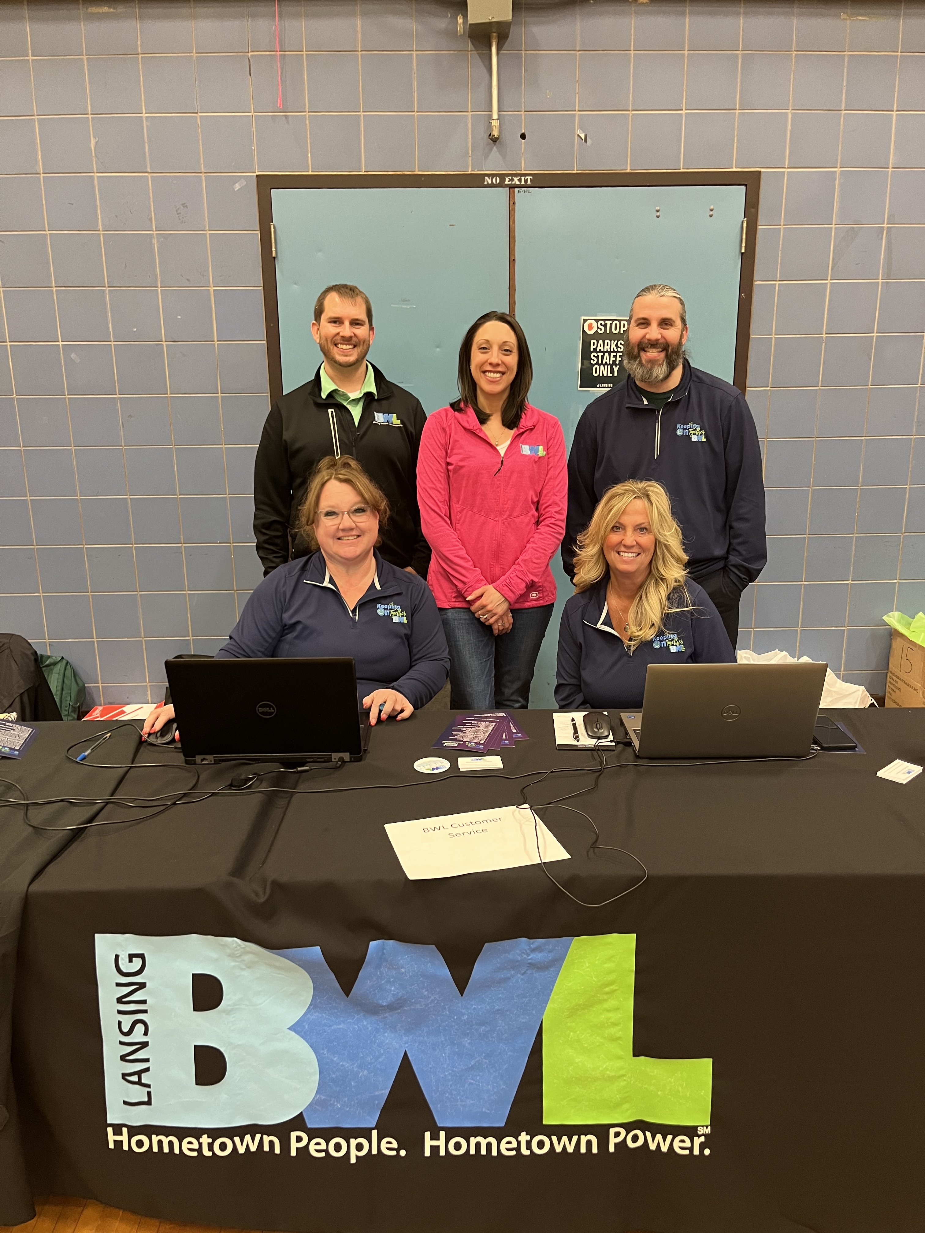 a group of people smiling behind a table