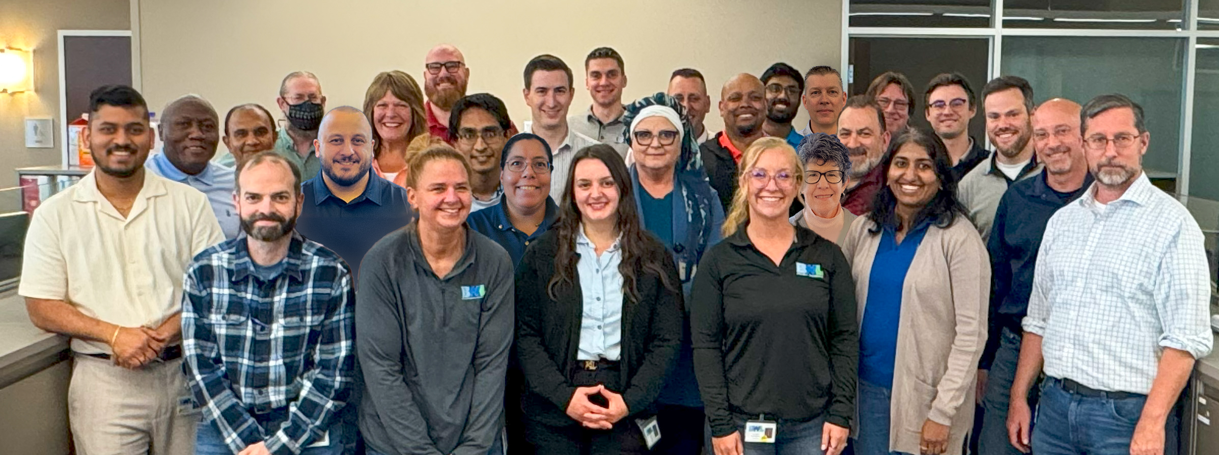 People standing in a group for a photo in an office setting