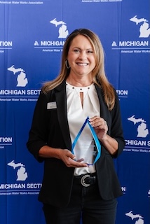 lady standing holding a glass trophy