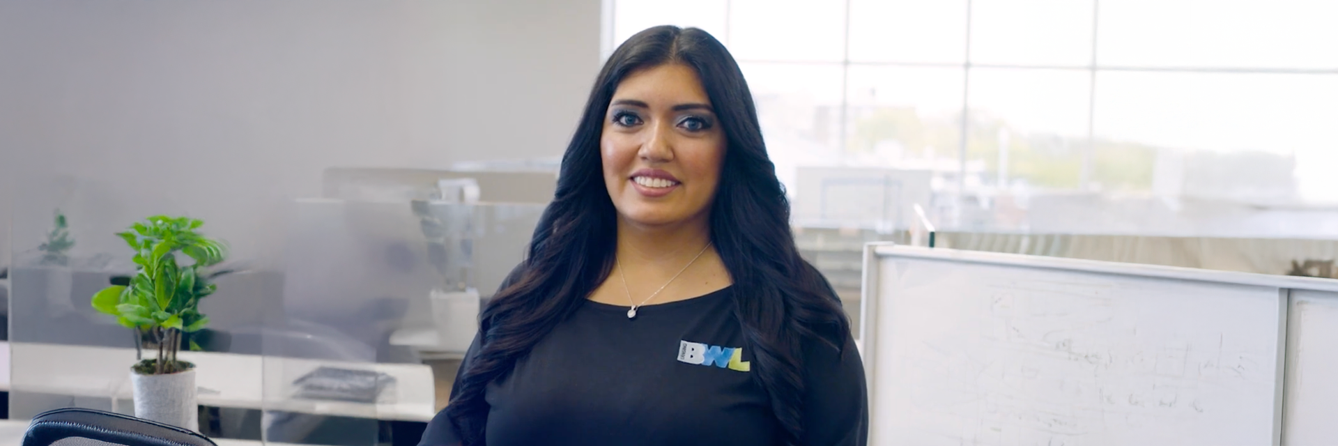 lady with dark hair and a black shirt smiling at the camera