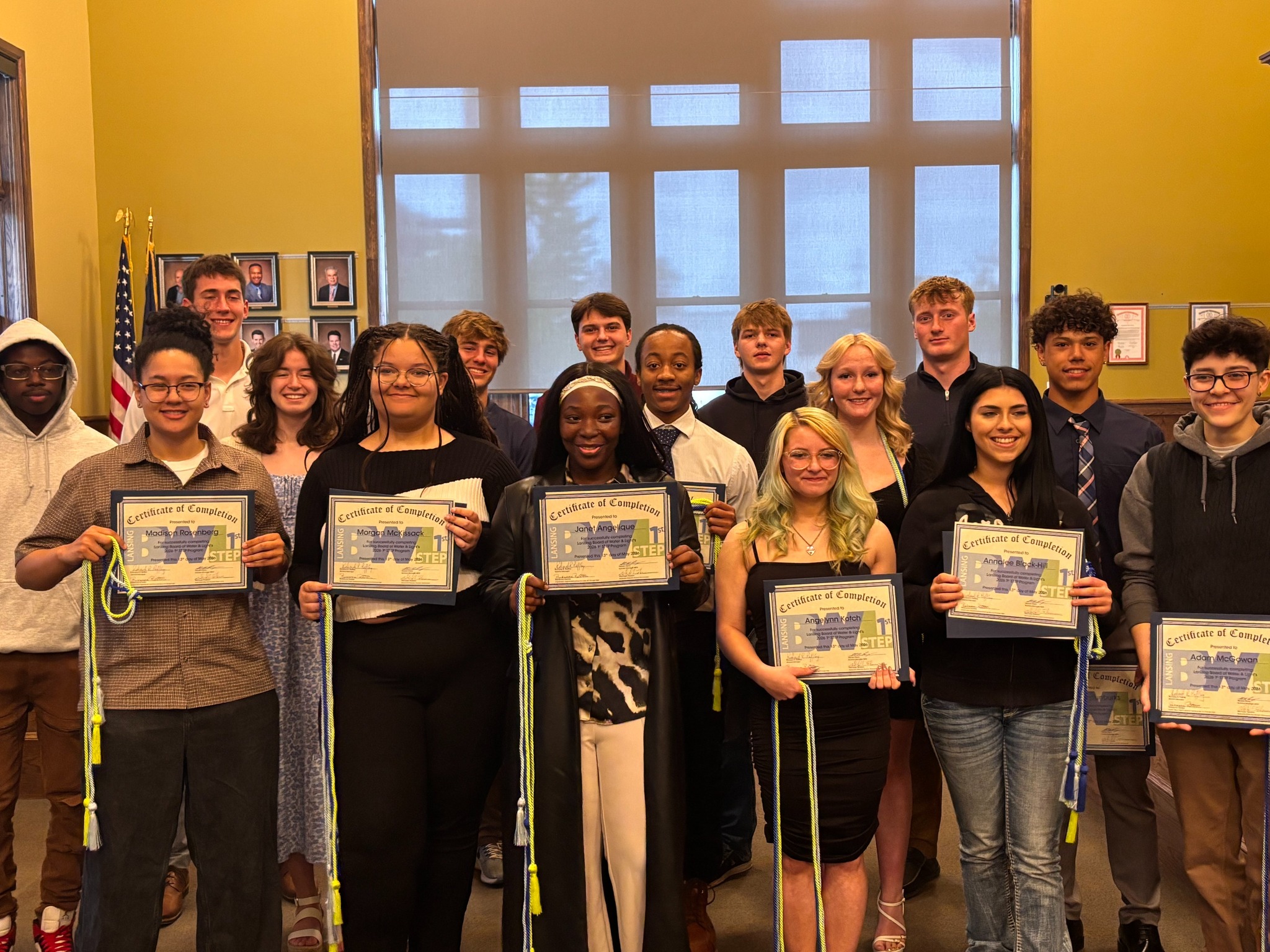a group of students after graduation with cords and holding up certificates