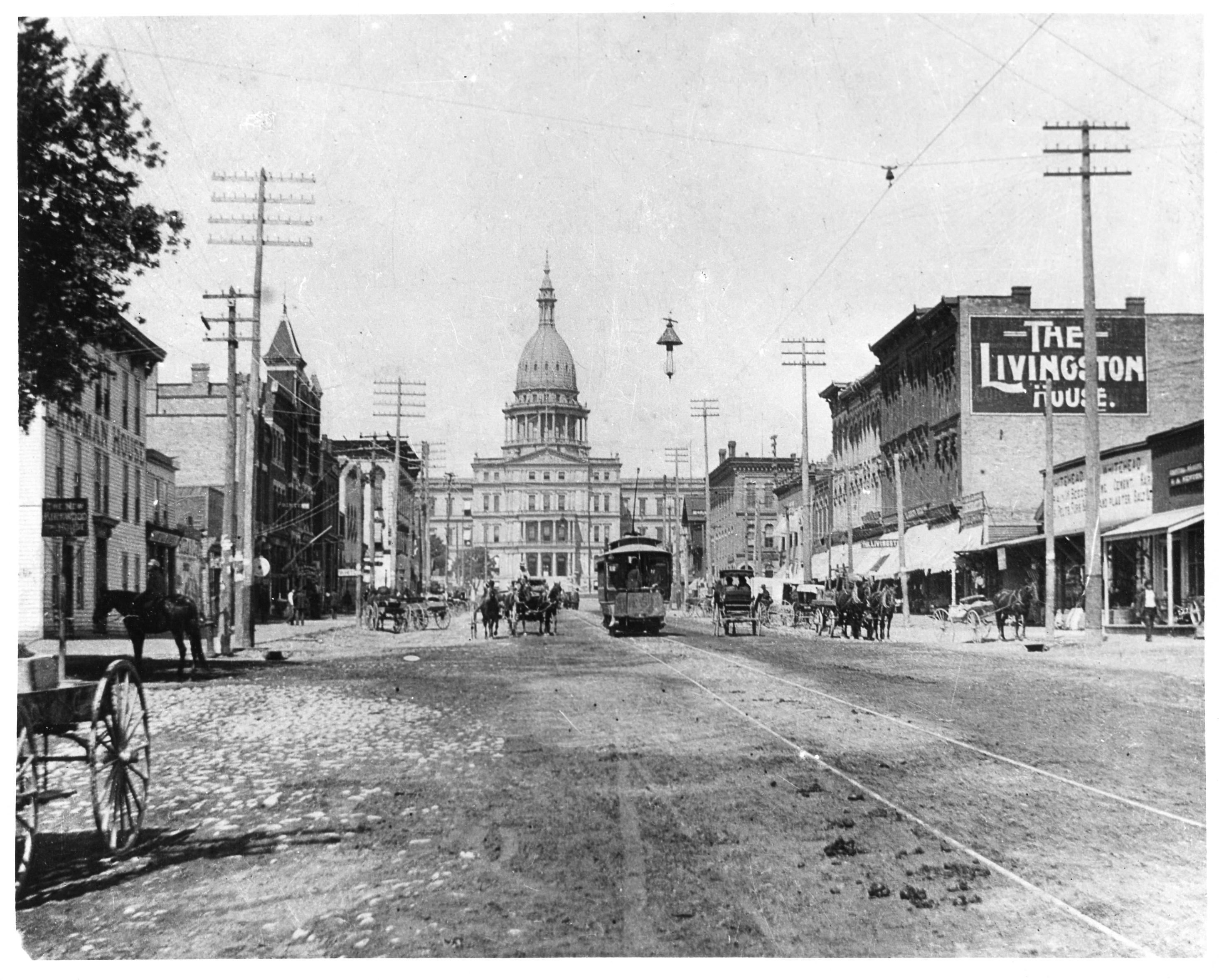 a dirt road with building on the left and right side, looking toward the capitol building.