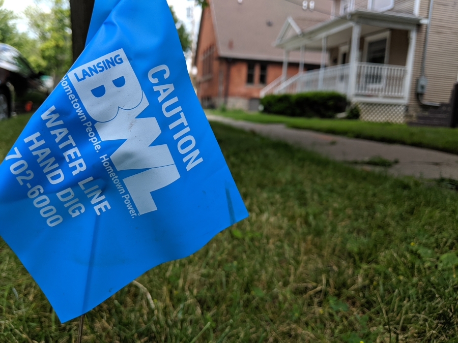 A blue utility flag sticks in the ground